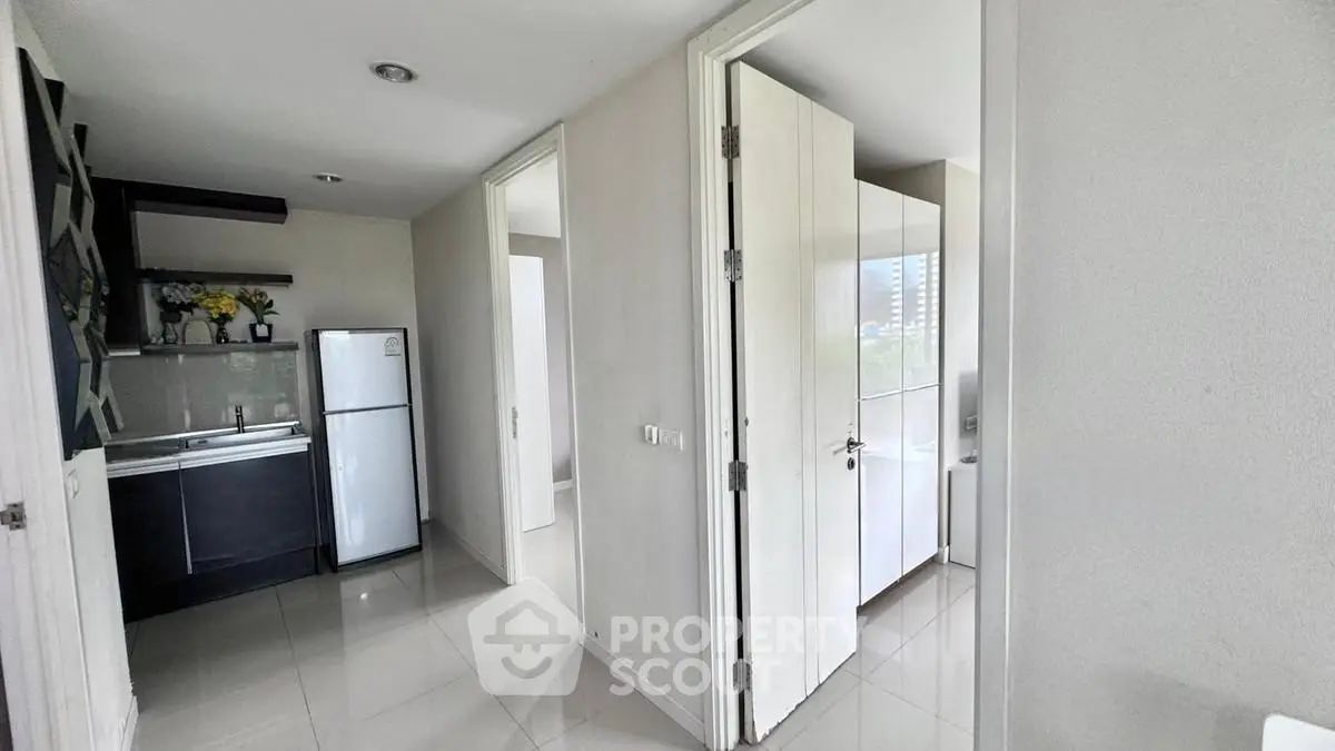 Modern apartment hallway with sleek kitchen and bright natural light