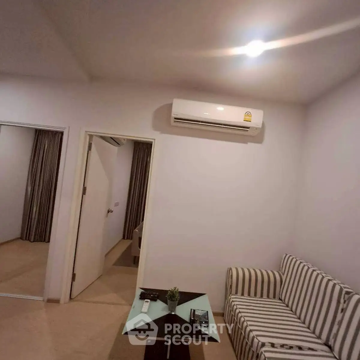 Cozy living room with striped sofa and modern air conditioning unit