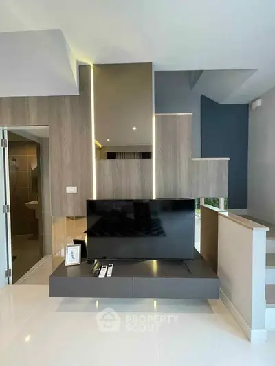 Modern living room with sleek TV setup and stylish wooden paneling