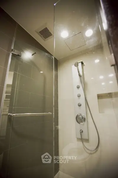 Modern bathroom with sleek shower panel and glass enclosure
