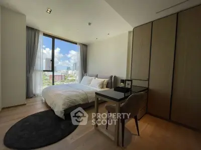 Modern bedroom with city view, featuring sleek furniture and large windows for natural light.