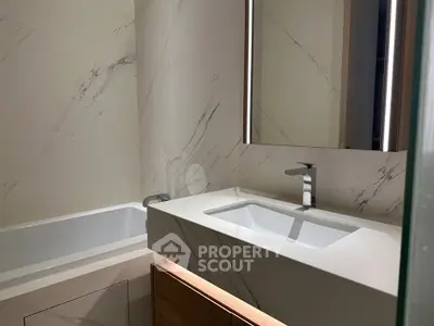 Modern bathroom with sleek marble finishes and integrated lighting