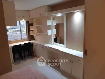 Modern bedroom with built-in desk and storage, featuring sleek design and ample natural light.