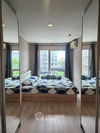 Modern bedroom with large mirrors and city view, featuring stylish decor and ample natural light.