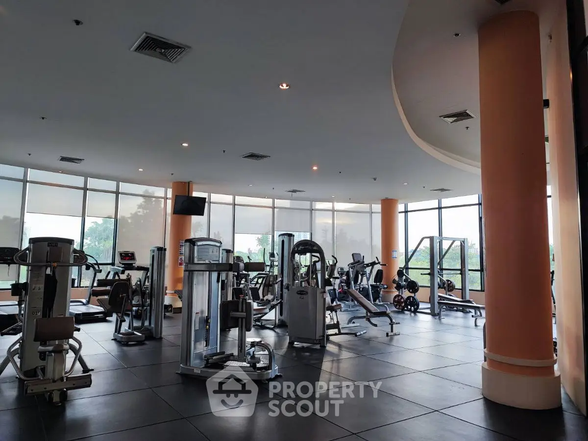 Spacious modern gym with state-of-the-art fitness equipment and large windows offering scenic views.
