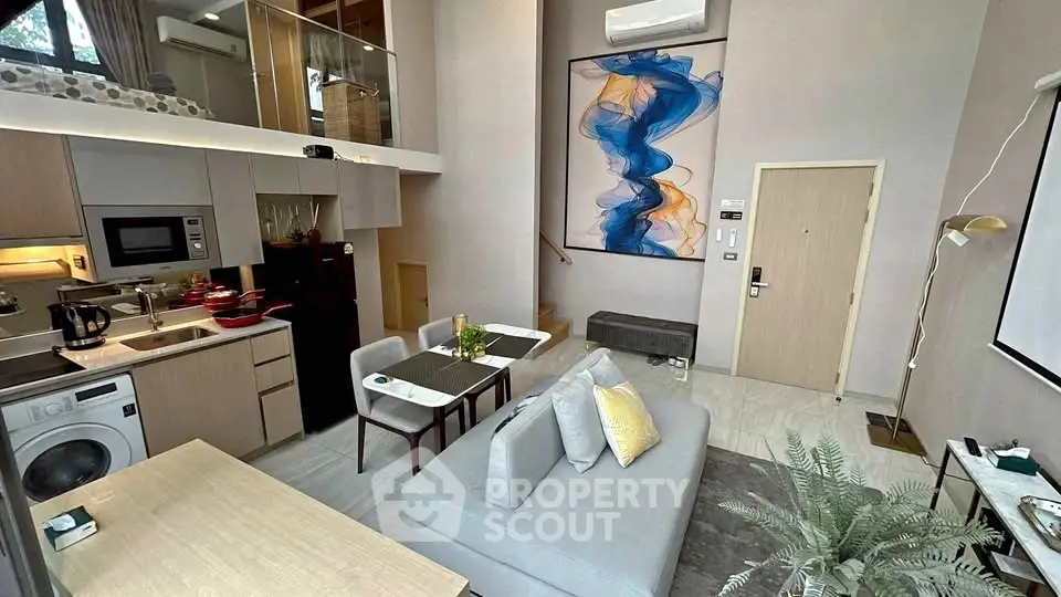 Modern loft apartment with open kitchen and stylish living area, featuring contemporary decor and high ceilings.