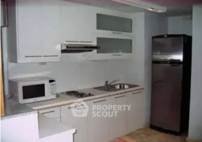Modern kitchen with sleek appliances and minimalist design in a cozy apartment.
