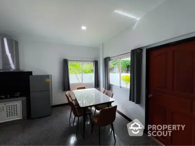 Modern kitchen with sleek dining area and large windows for natural light