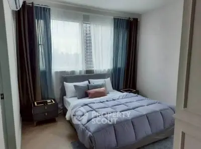 Cozy bedroom with modern decor and large window for natural light.