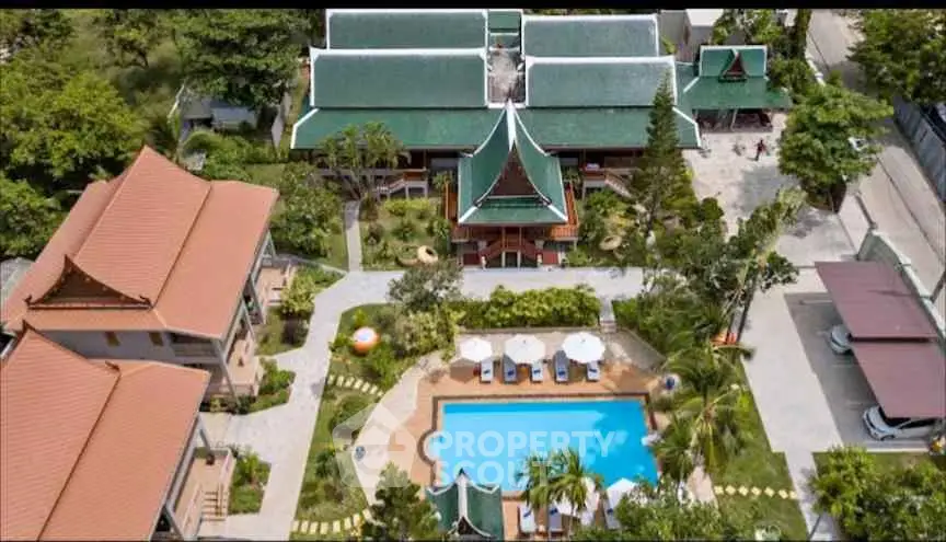 Stunning aerial view of a luxurious resort with traditional architecture and inviting pool area.