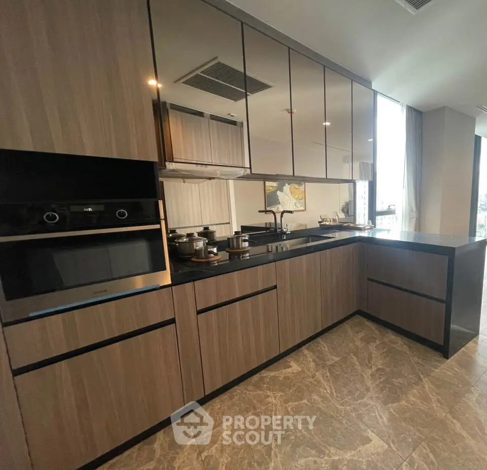 Modern kitchen with sleek cabinetry and built-in oven in luxury apartment