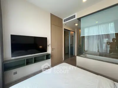 Modern bedroom with wall-mounted TV and glass partition