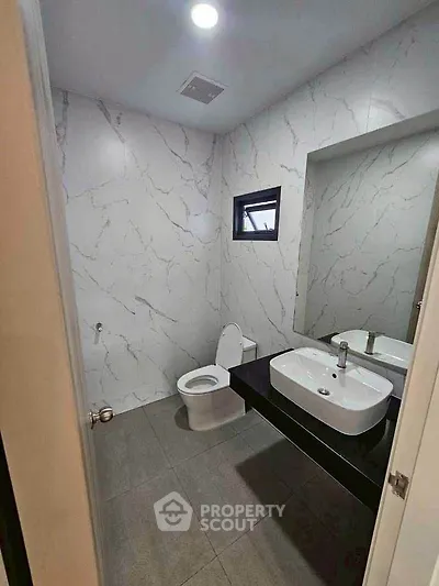 Modern bathroom with sleek design, featuring a stylish sink and elegant marble walls.