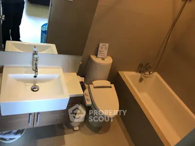 Modern bathroom with sleek fixtures and a bathtub in a contemporary apartment.