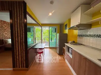 Charming kitchen with open layout and balcony view, featuring modern appliances and vibrant decor.