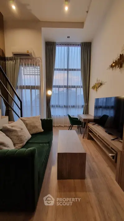 Modern living room with high ceilings and stylish decor in a cozy apartment.
