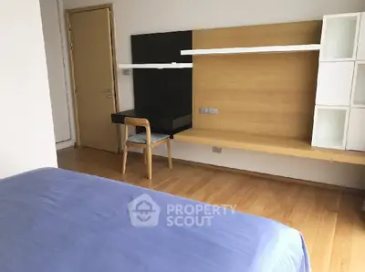 Modern bedroom with wooden flooring and stylish desk setup