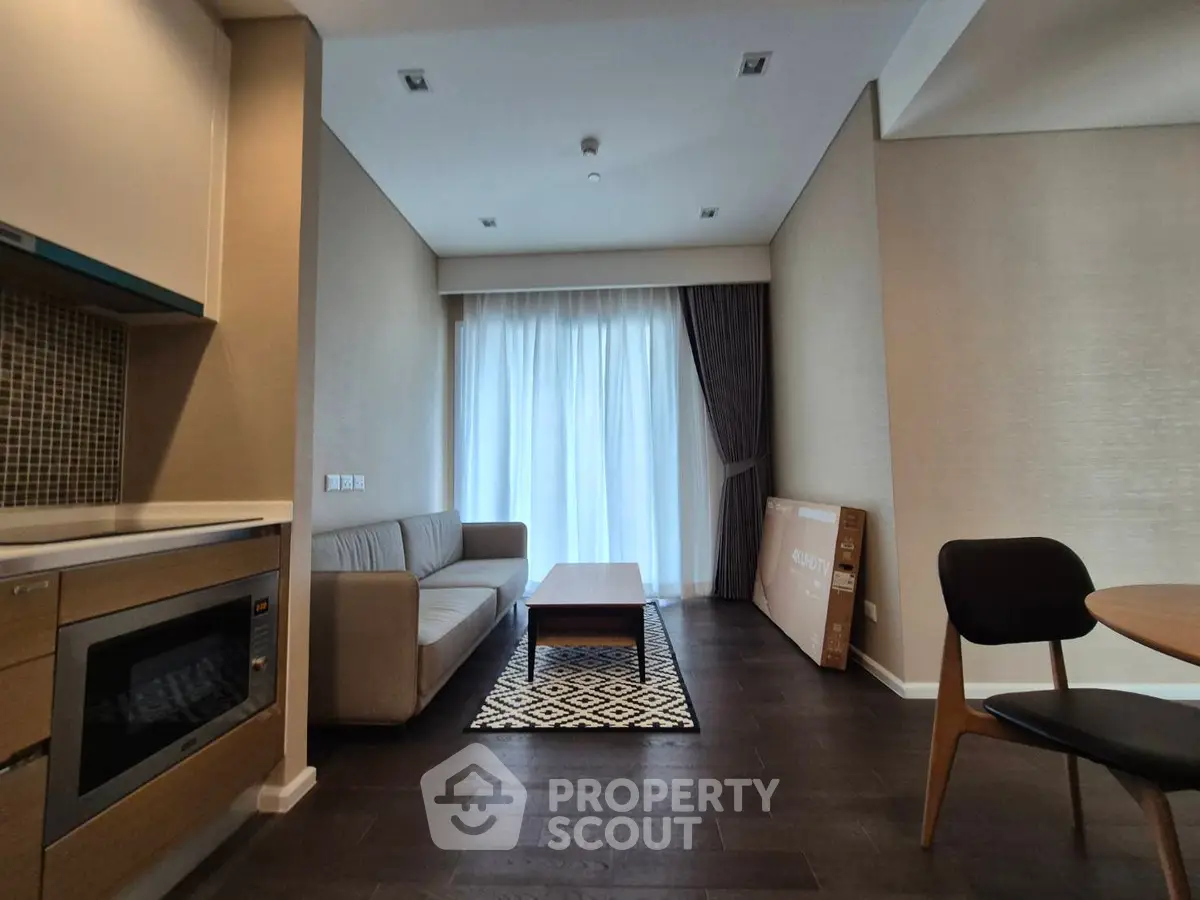 Modern living room with sleek furniture and natural light, featuring a cozy sofa and stylish decor.