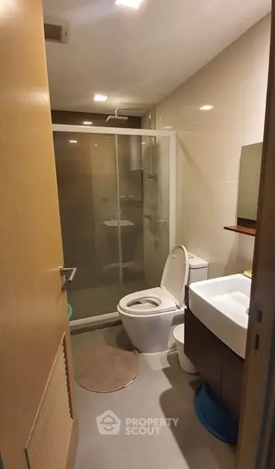 Modern bathroom with glass shower, sleek fixtures, and neutral tones for a contemporary feel.