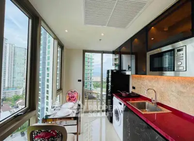 Modern kitchen with red countertops, washing machine, and city view from balcony.