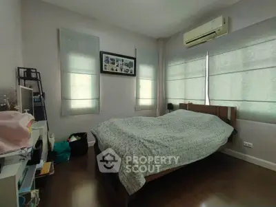 Cozy bedroom with natural light and air conditioning, perfect for relaxation.