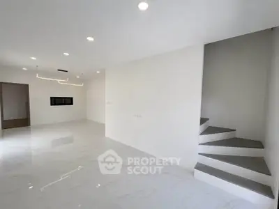 Spacious modern living room with sleek staircase and elegant lighting