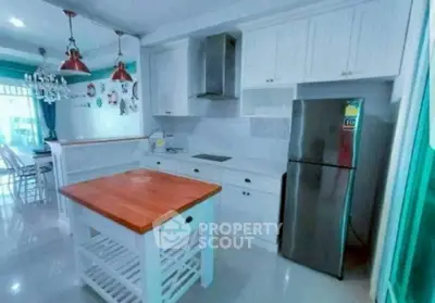 Charming kitchen with island and stainless steel fridge in modern home