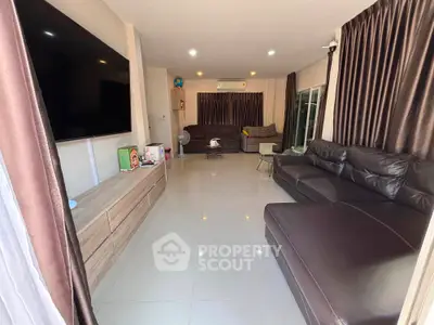 Spacious modern living room with sleek leather sofas and large flat-screen TV