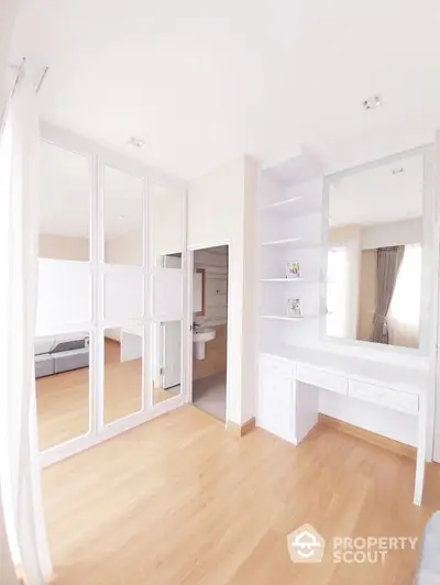 Bright and spacious bedroom with elegant wooden flooring and built-in wardrobe