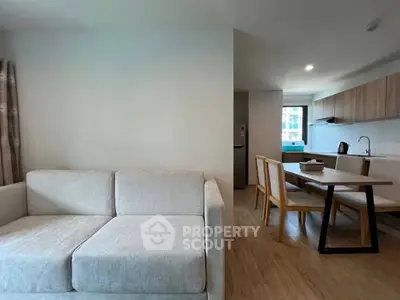 Modern open-plan living room and kitchen with stylish furniture and natural light.