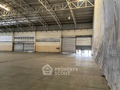 Spacious industrial warehouse with high ceilings and large roller doors