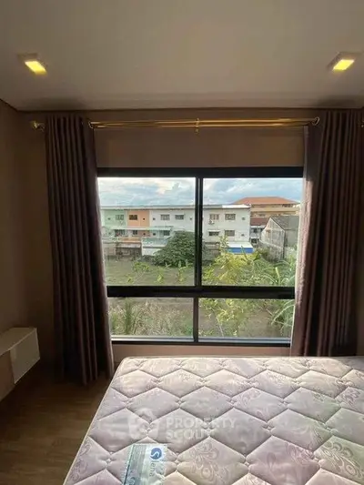 Spacious bedroom with large window offering a scenic view of the neighborhood.