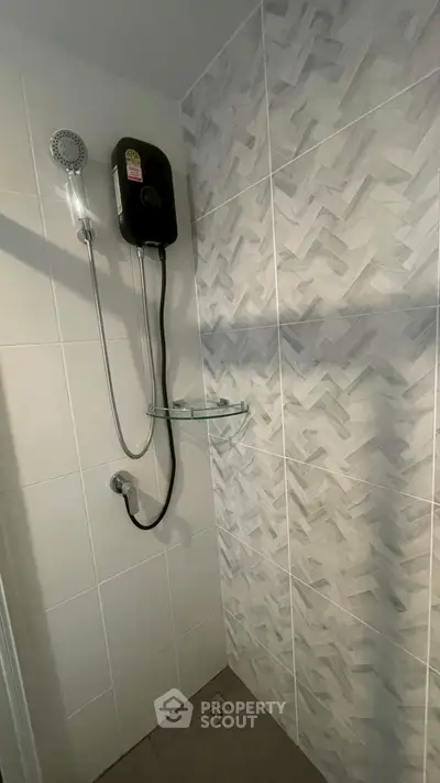 Modern bathroom shower area with sleek tiles and glass shelf
