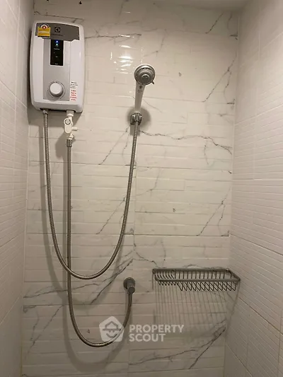 Modern bathroom shower with sleek white tiles and water heater