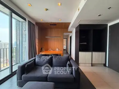 Modern living room with city view, featuring sleek furniture and stylish decor in a high-rise apartment.