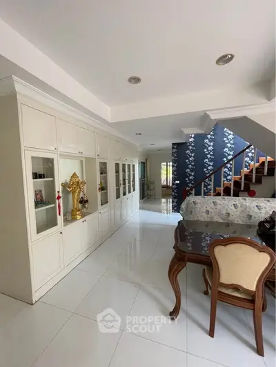 Spacious living room with elegant staircase and built-in cabinets
