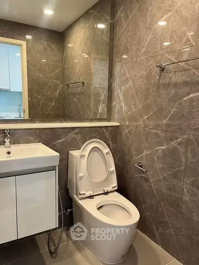 Modern bathroom with sleek marble tiles and contemporary fixtures.