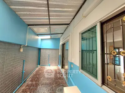 Spacious enclosed balcony with modern blue accents and tiled flooring