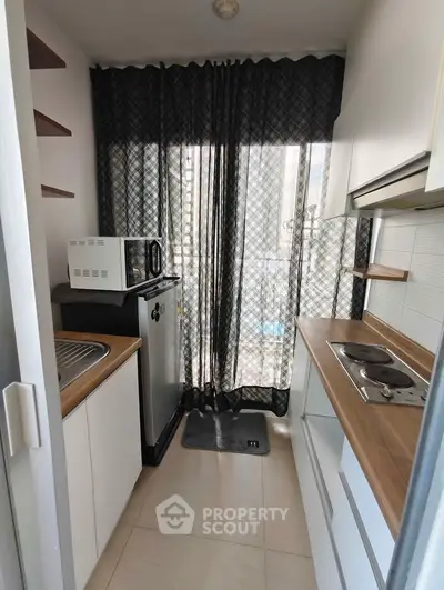 Compact kitchen with modern appliances and natural light