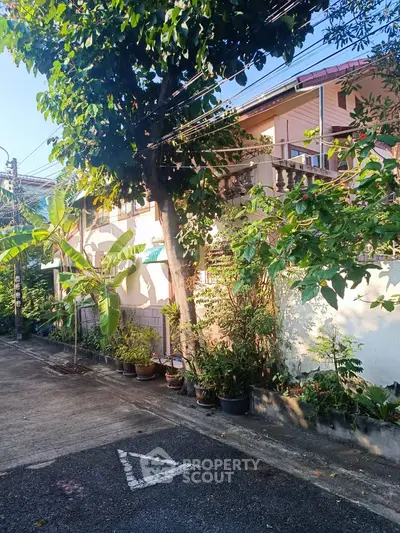 Charming residential house with lush greenery and spacious balcony in a serene neighborhood.