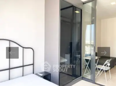 Modern bedroom with glass partition and balcony view in a stylish apartment
