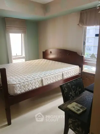 Cozy bedroom with wooden bed frame and natural light