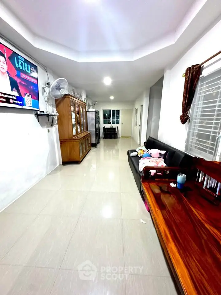 Spacious living room with modern furnishings and bright lighting, perfect for family gatherings.