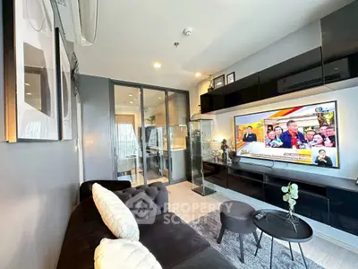 Modern living room with sleek design, featuring a wall-mounted TV and stylish furniture.
