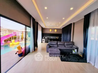 Luxurious living room with pool view and modern open kitchen layout, perfect for family gatherings.