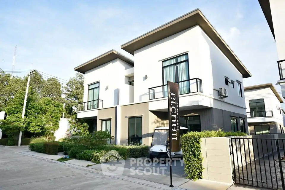 Modern two-story house with sleek design and lush greenery in a serene neighborhood.