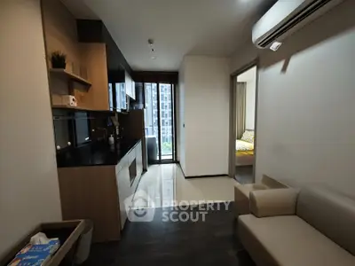 Modern apartment interior with sleek kitchen and cozy living area, featuring a view of the cityscape.