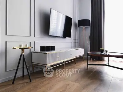 Modern living room with sleek furniture and mounted TV, featuring elegant decor and natural light.