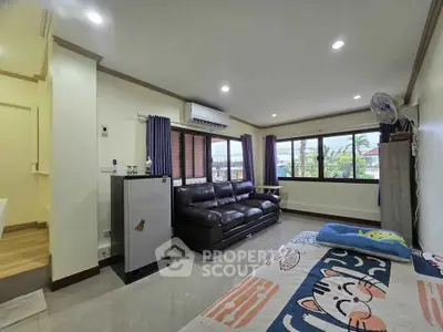 Spacious living room with large windows and modern furnishings, perfect for relaxation and entertaining.