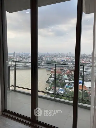 Stunning high-rise apartment with panoramic city and river views from a spacious balcony.
